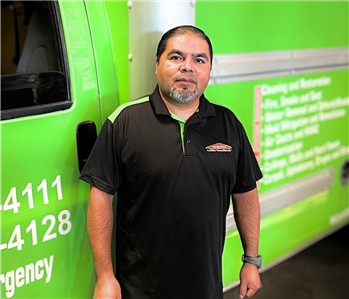 male employee in front of green box truck